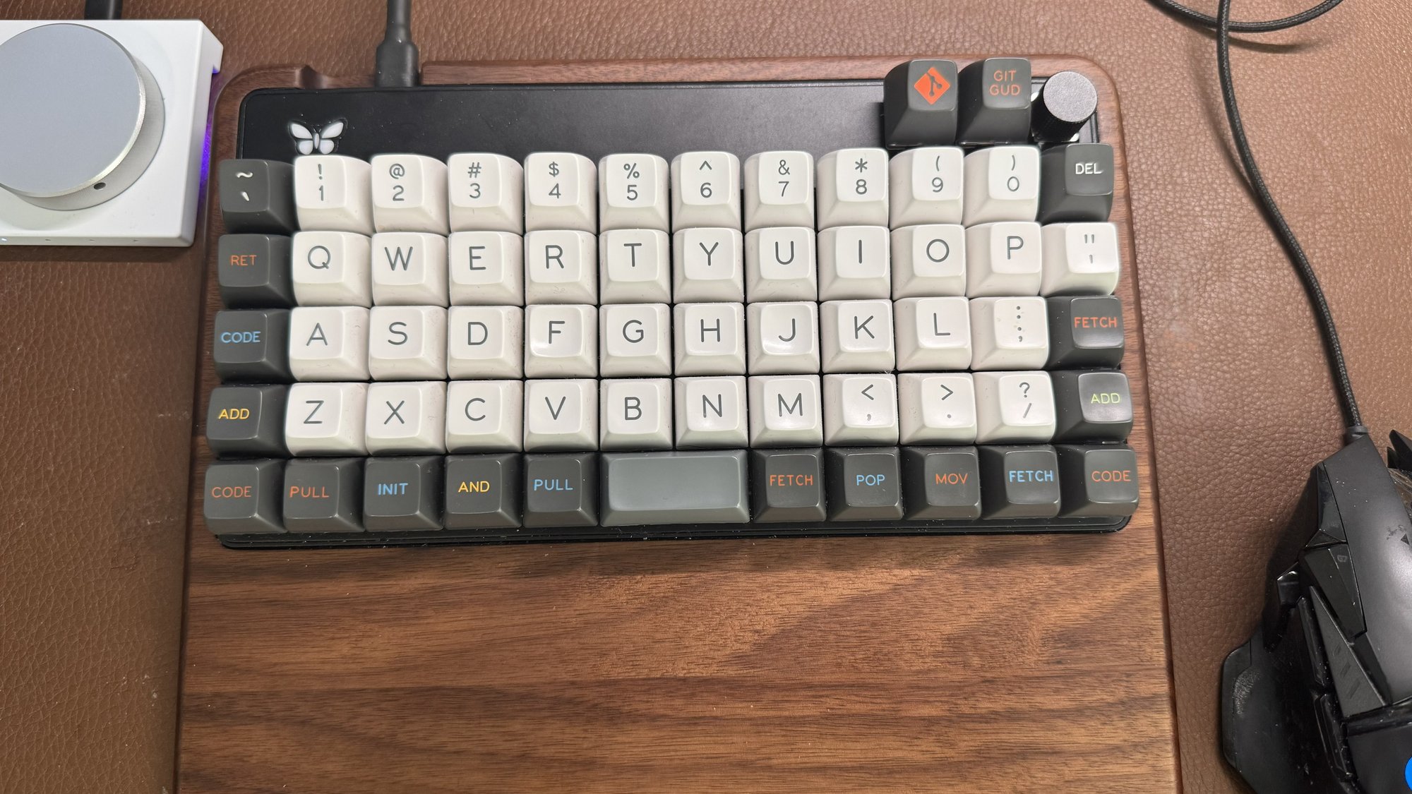 Top-down view of our Keyboardio Preonic showing the butterfly logo, rotary knob, and SA Oblivion git-themed keycaps